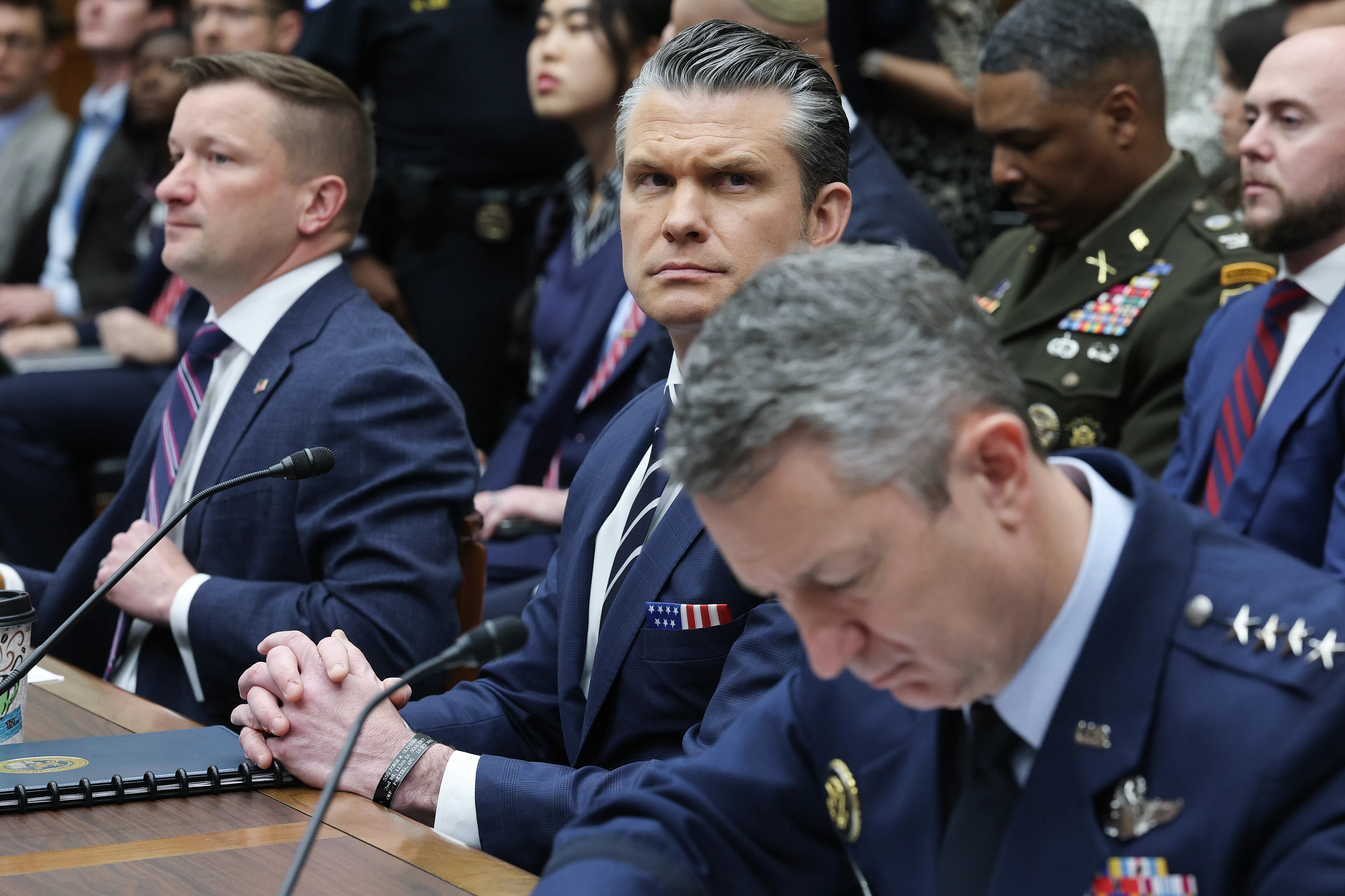 Assistant Defense Secretary Jules Hurst, Defense Secretary Pete Hegseth, and Chairman of the Joint Chiefs of Staff Dan Caine sit in a House committee hearing