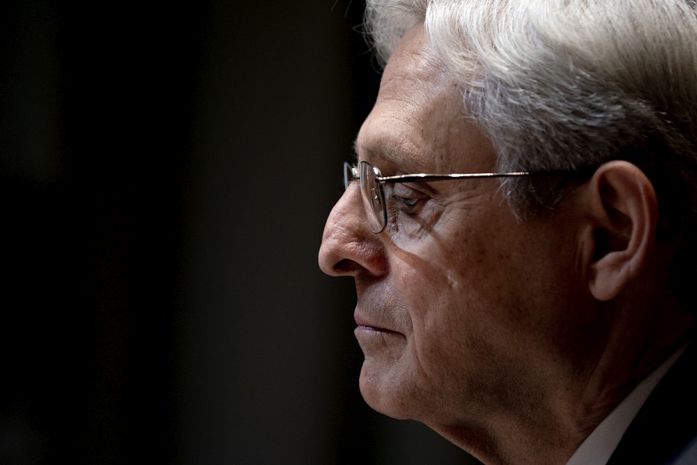 Merrick Garland looks down at his desk during a hearing.
