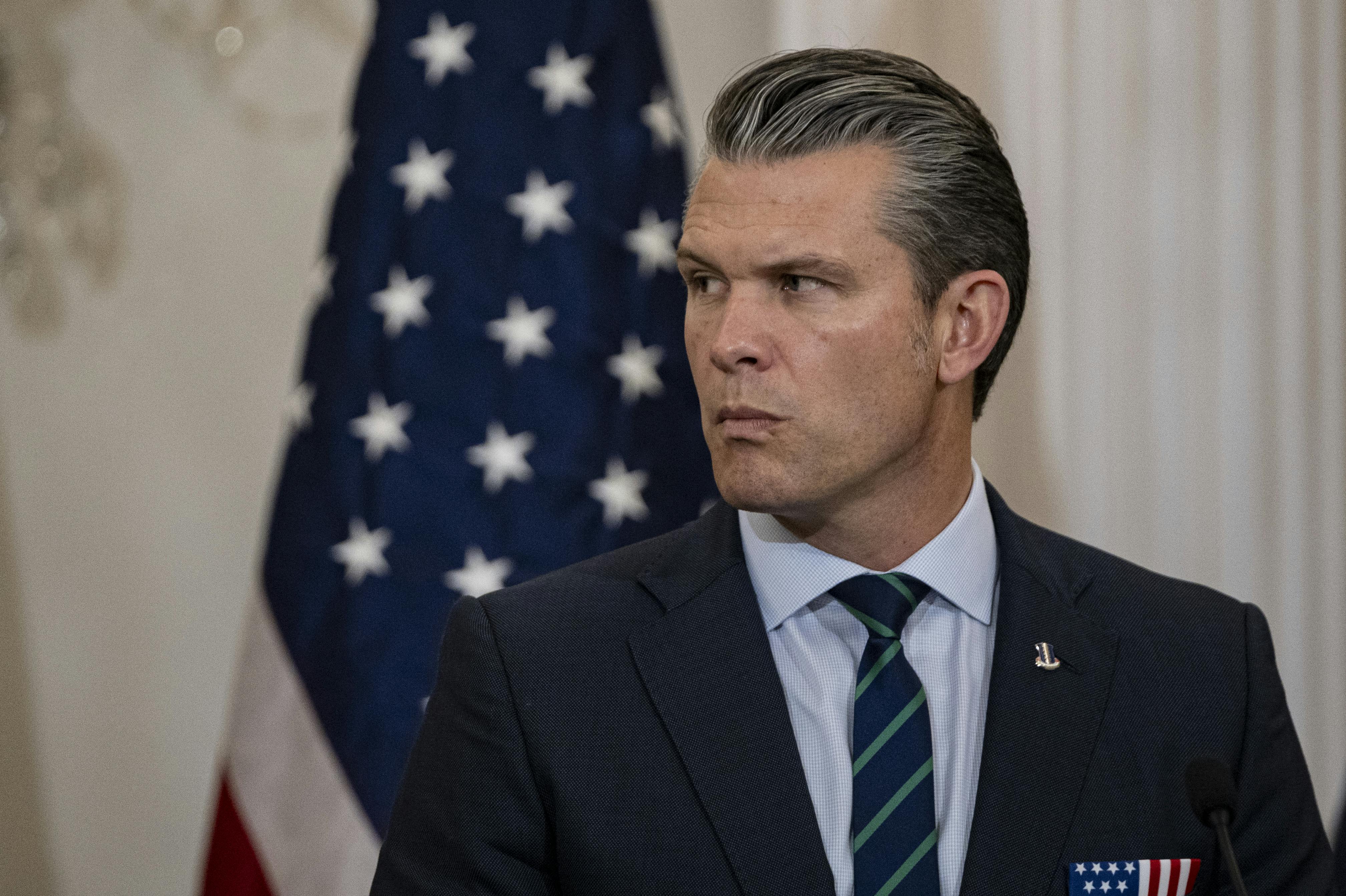 Defense Secretary Pete Hegseth purses his lips and turns his head to the side