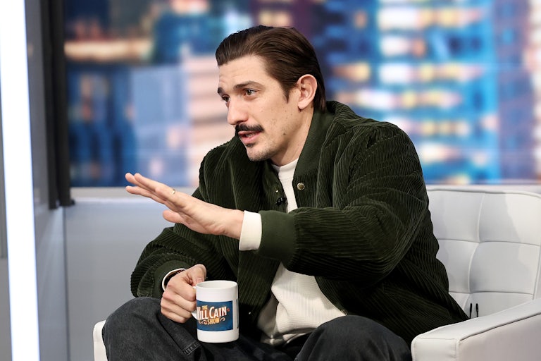 Andrew Schulz holds a coffee cup and puts an hand out as he speaks on "The Will Cain Show" on Fox News.