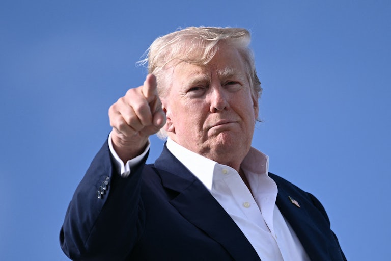 Donald Trump points at the camera and smiles