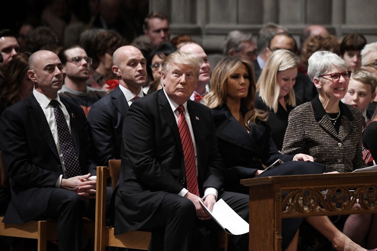 Donald Trump sits in the cathedral pews next to Melania Trump.