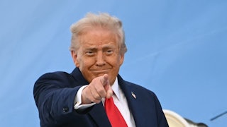Donald Trump smiles and points while boarding Air Force One