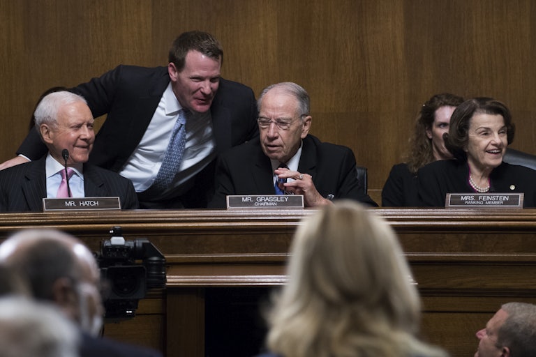 Mike Davis leans over in a congressional briefing to talk to Chuck Grassley