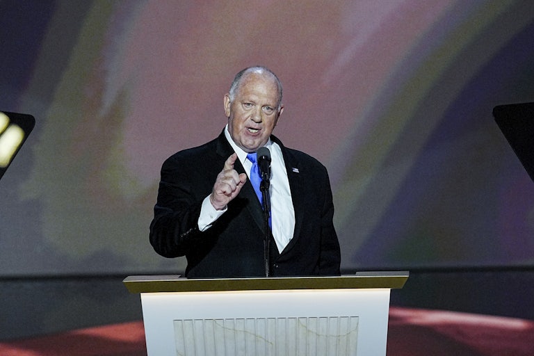 Tom Homan gestures while speaking at a podium