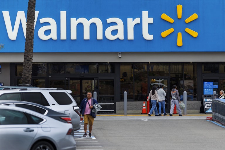 People walk in a Walmart parking lot