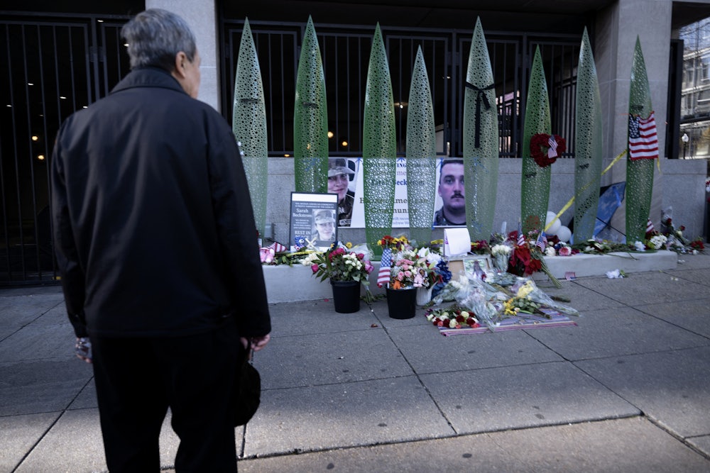 A person looks at a memorial for the two National Guard members who were shot in Washington, D.C.