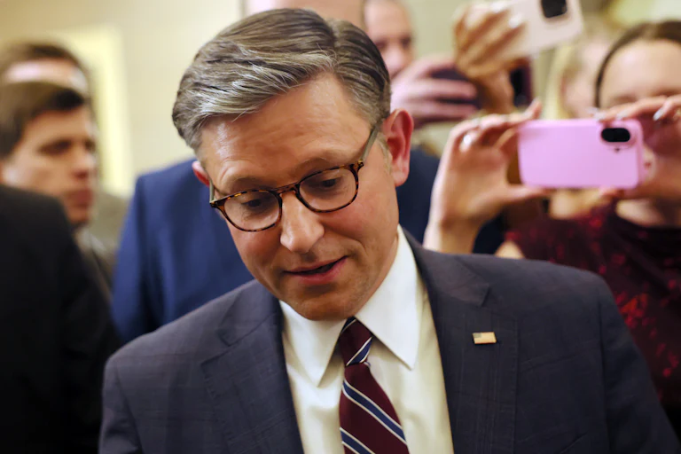 House Speaker Mike Johnson looks down while walking in the Capitol