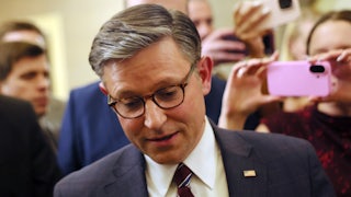 House Speaker Mike Johnson looks down while walking in the Capitol