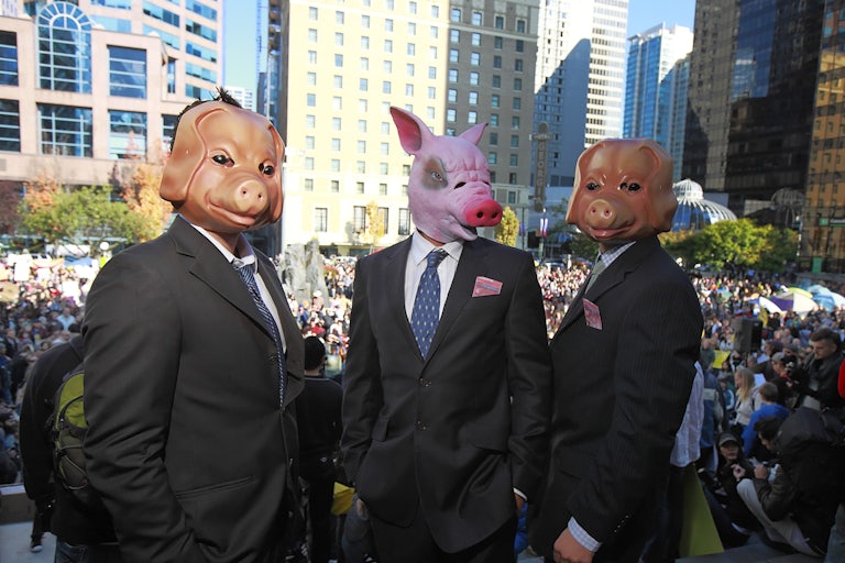 Activists wear pig masks to protest Wall Street greed.