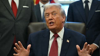 Donald Trump speaks at his desk in the Oval Office of the White House.
