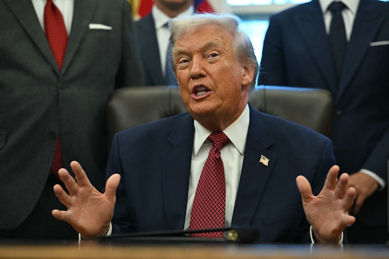 Donald Trump speaks at his desk in the Oval Office of the White House.