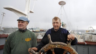 Whaler and captain Olafur Olafsson and his number two Hafstian Omar thorstainsson stand at the helm of a restored whaling vessel.