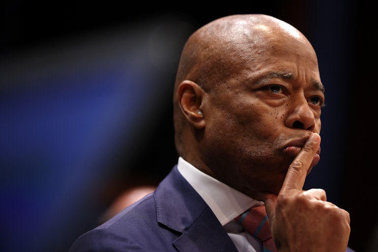 NYC Mayor Eric Adams puts his index fingers on his lips as if to tell someone to be quiet.