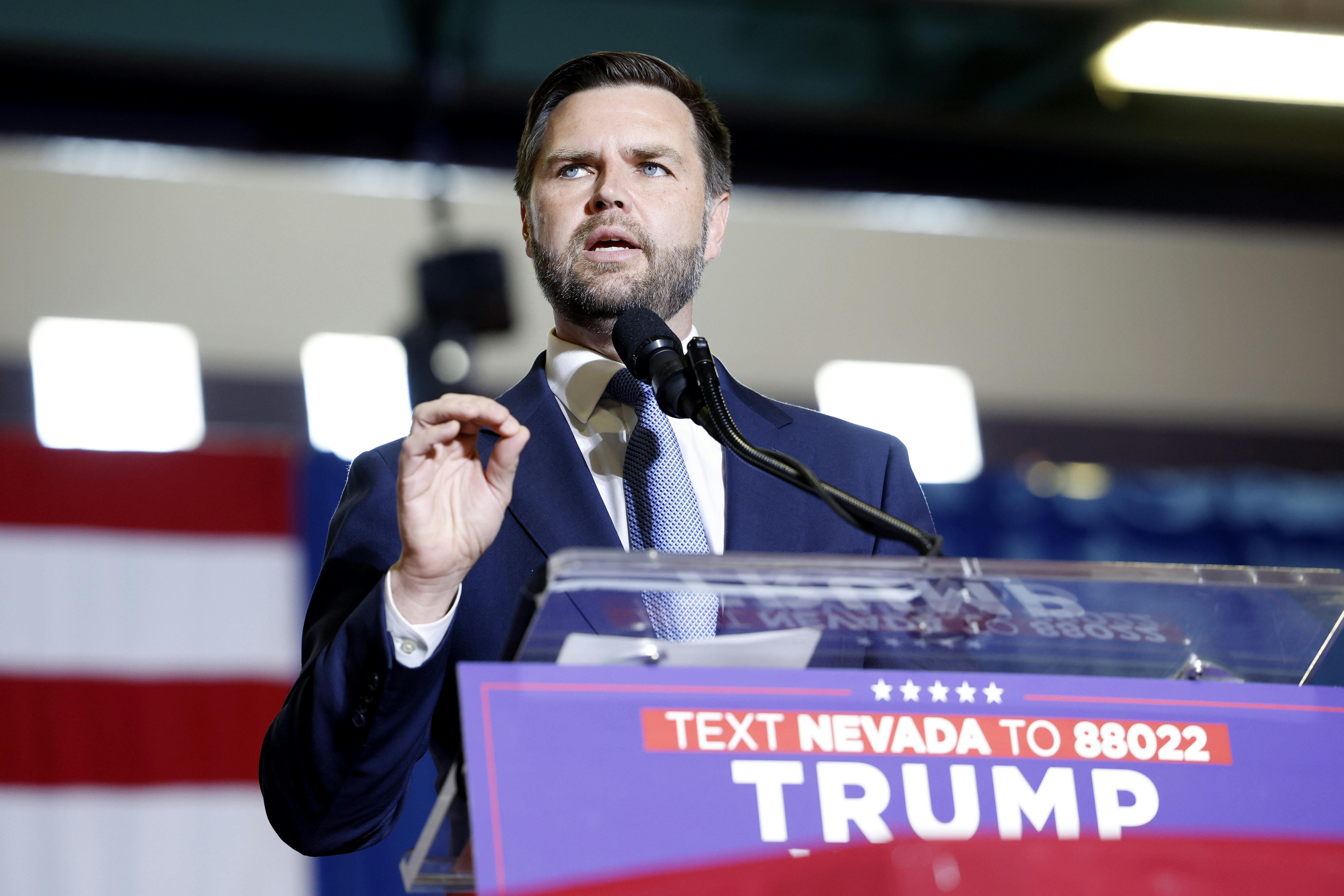J.D. Vance gestures while speaking at a podium.