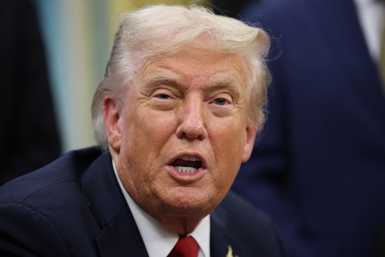 Donald Trump speaks while sitting at his desk in the Oval Office