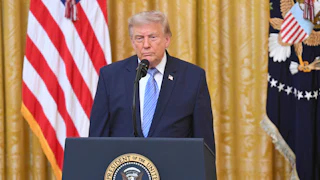 Donald Trump stands at a podium during a national address