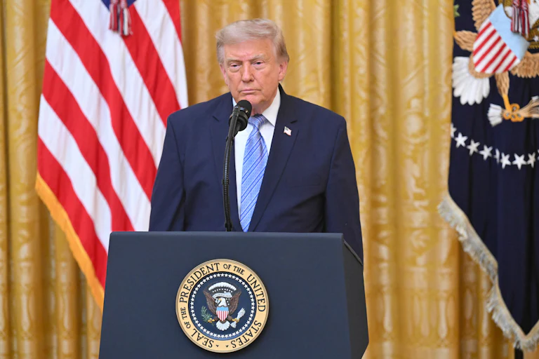 Donald Trump stands at a podium during a national address.
