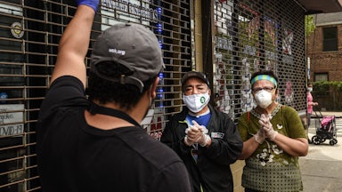 A worker wearing gloves and a Covid mask must turn away two people waiting in line to receive food from a community pantry.