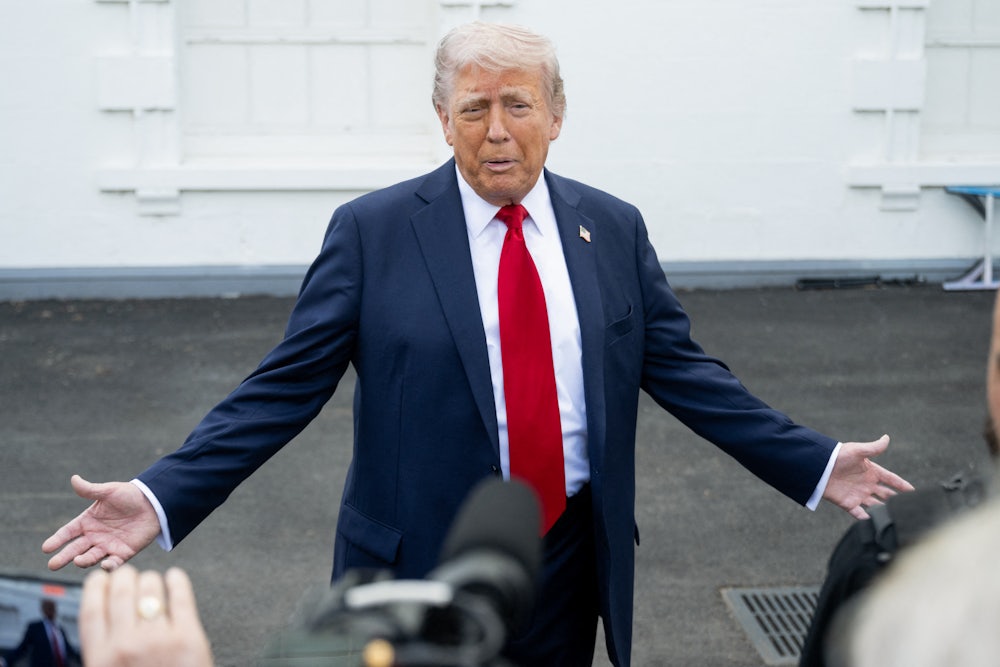 Donald Trump stretches his arms outward as he speaks with reporters outside.