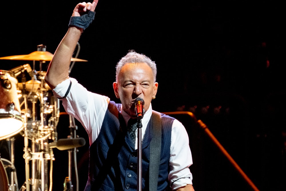 Bruce Springsteen raises his hand while performing onstage in Manchester, England