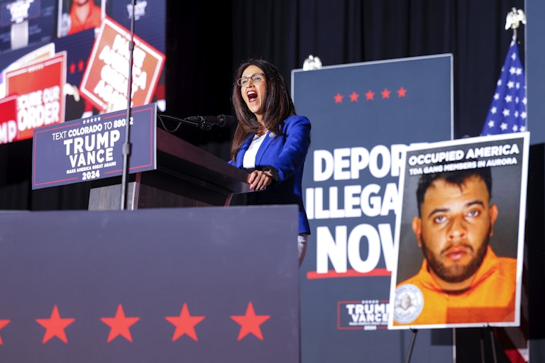 Lauren Boebert speaks in front of a sign that says, “Deport Illegals Now” at a Donald Trump rally