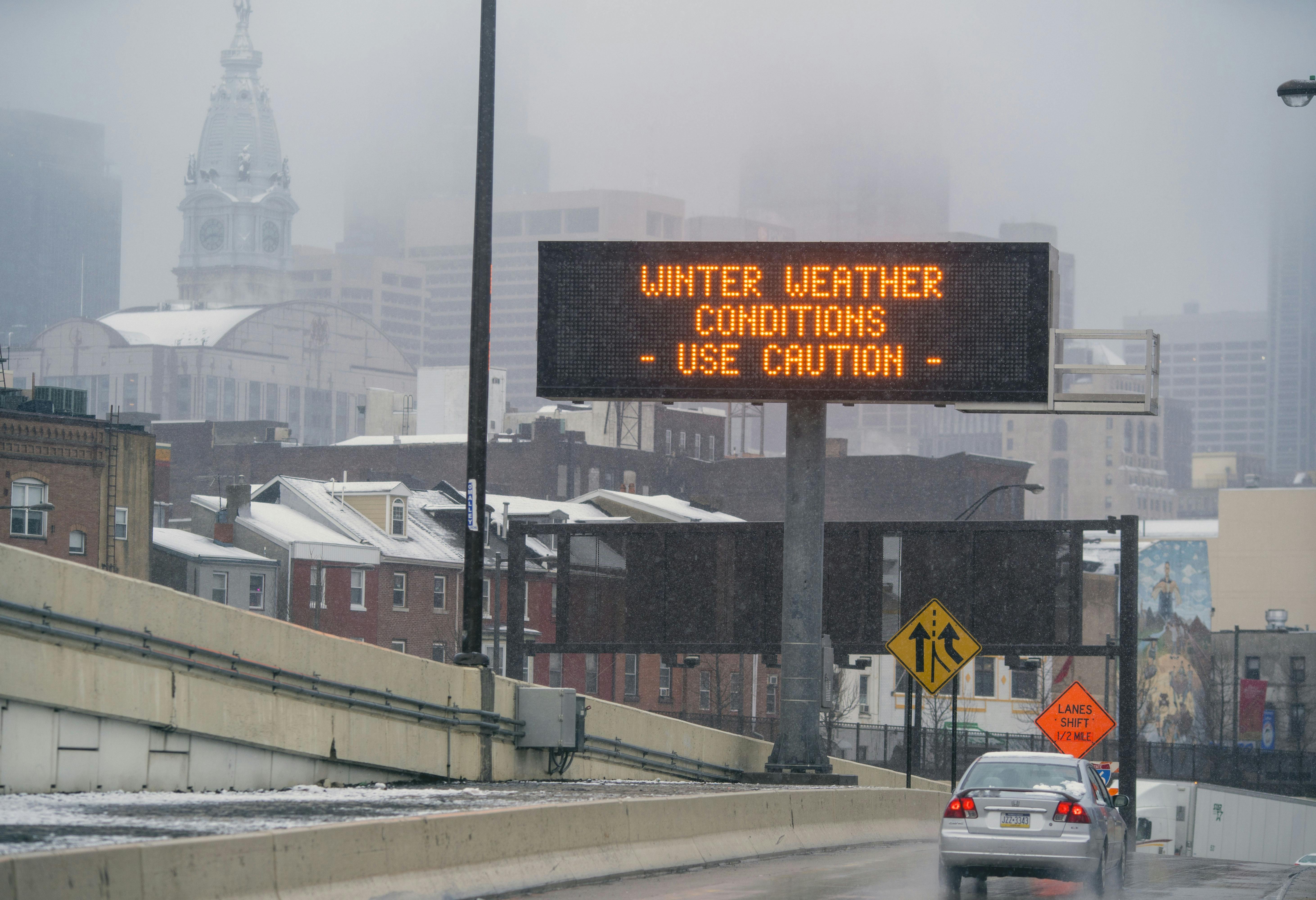 A sign on the road reads "Winter Weather Conditions Use Caution."