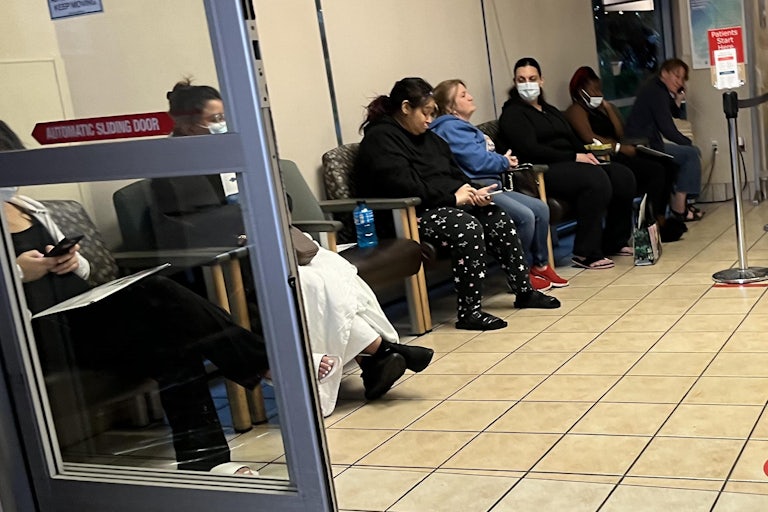 People sitting in a row of chairs in an emergency room at Saint Agnes Medical Center in Fresno, California, on May 9, 2023.