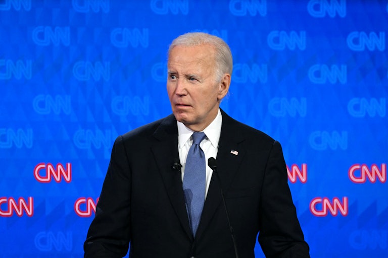Joe Biden looks to his right on a debate stage, with a grimace on his face.