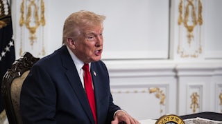Donald Trump speaks while sitting at a desk in Mar-a-Lago