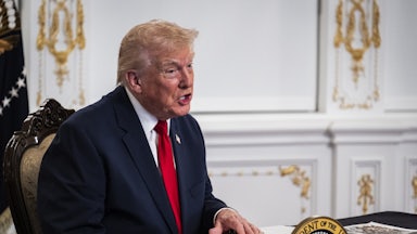 Donald Trump speaks while sitting at a desk in Mar-a-Lago
