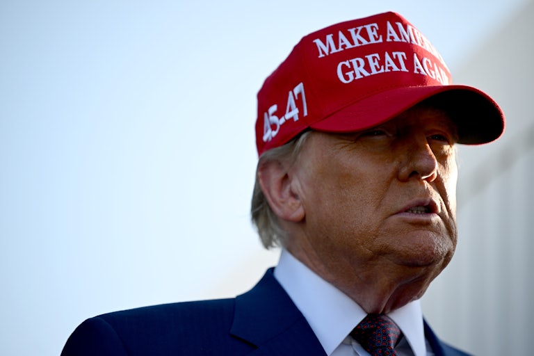 Donald Trump wearing a red MAGA cap outside