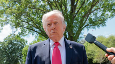 Donald Trump speaks with reporters outside the White House