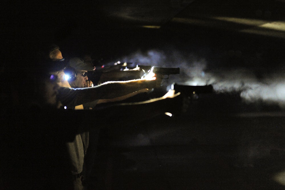 A line of men perform a nighttime gun drill.