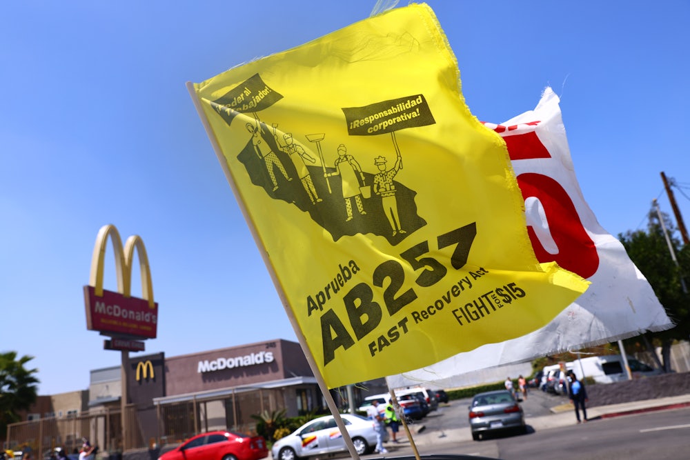 Flags in support of the FAST Recovery Act are flown at a rally of fast food workers and supporters outside a McDonalds in the Boyle Heights neighborhood of Los Angeles, California.