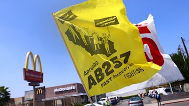 Flags in support of the FAST Recovery Act are flown at a rally of fast food workers and supporters outside a McDonalds in the Boyle Heights neighborhood of Los Angeles, California.