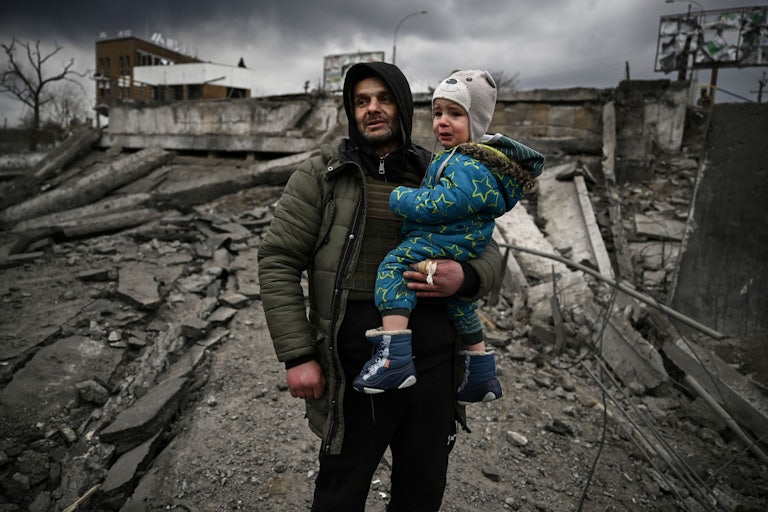 Man holds a child in city of Irpin, Ukraine