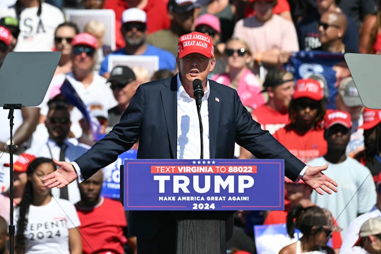 Donald Trump gestures as he speaks at a podium