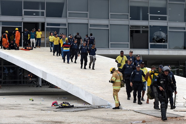Security forces arrest dozens of supporters of Brazilian former President Jair Bolsonaro who invaded Planalto Presidential Palace in Brasilia, leading them out of the building.