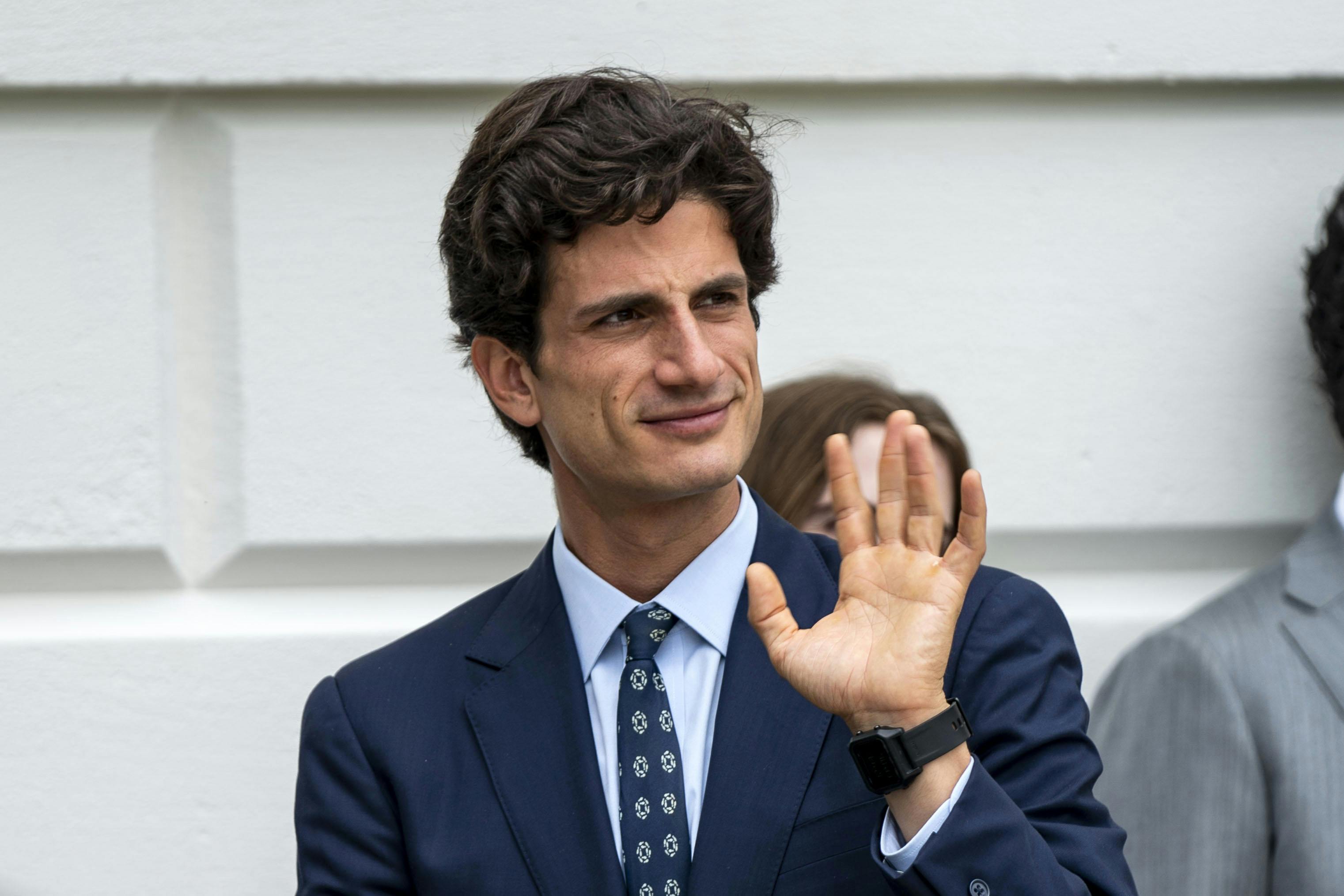 Jack Schlossberg waves while walking outside the White House