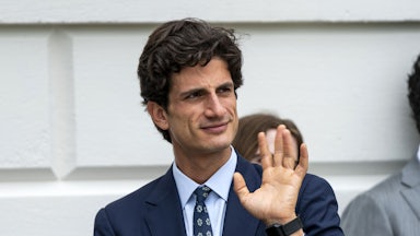 Jack Schlossberg waves while walking outside the White House