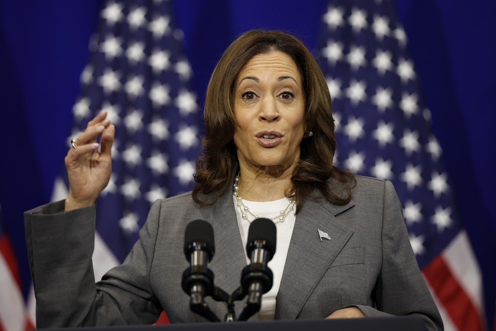 Kamala Harris speaks at a podium with American flags behind her.