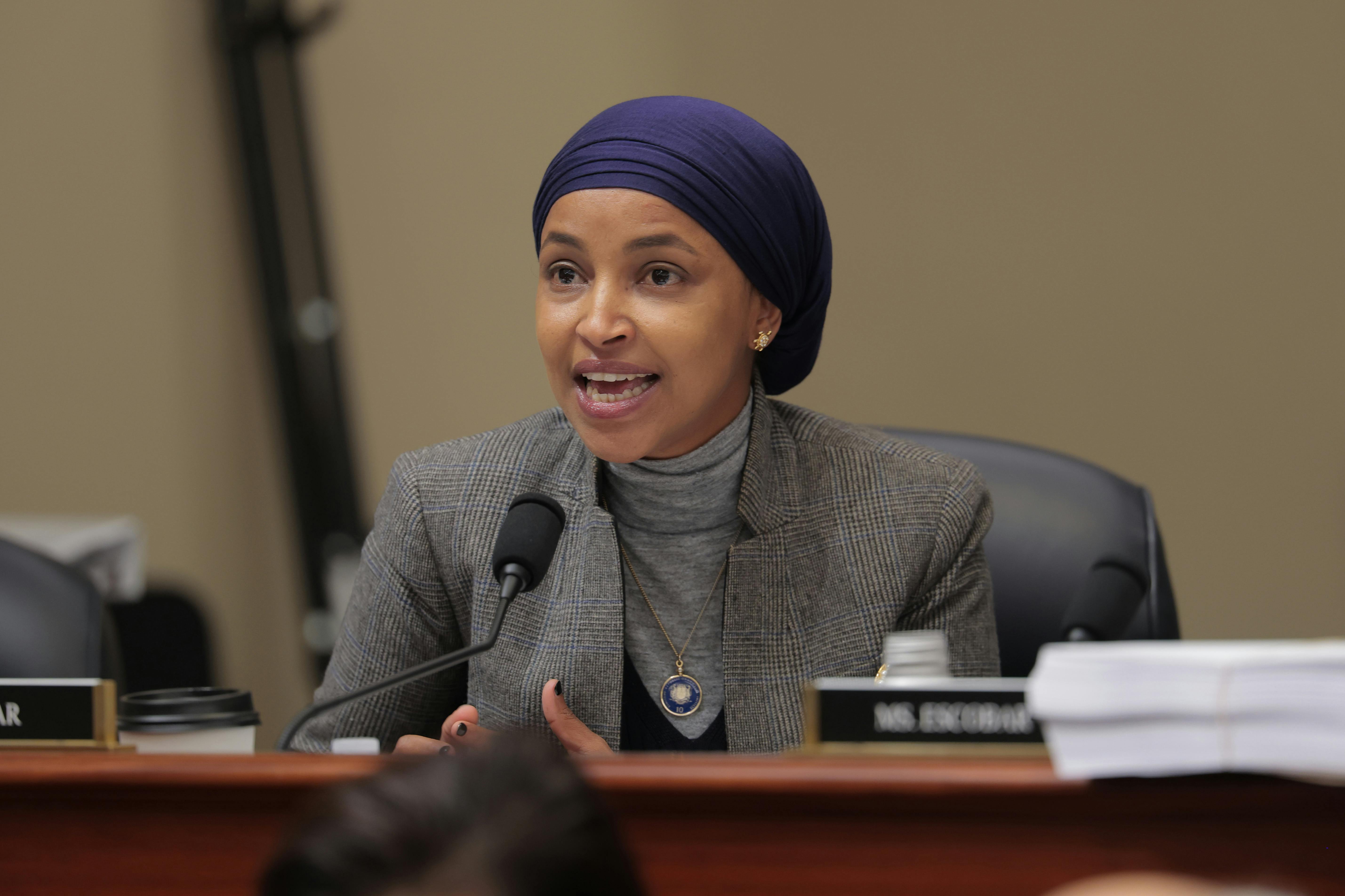 Representative Ilhan Omar speaks into a microphone during a House hearing