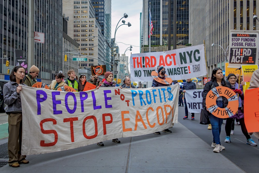 Activists hold signs reading "People not Profits" and "Third Act NYC."