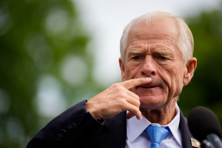 Peter Navarro speaks to reporters outside the White House (not pictured) and places a finger above his upper lip as if he's deep in thought.