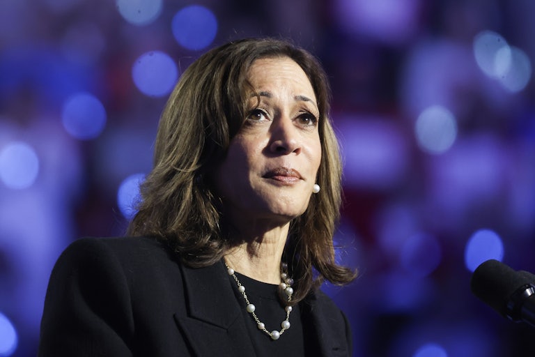 Kamala Harris looks up while standing in front of a microphone