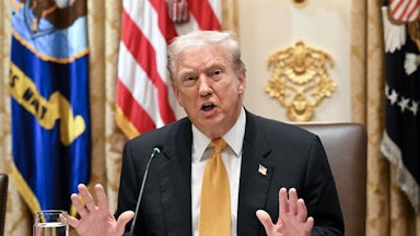 Donald Trump puts both hands up defensively as he speaks in the White House.