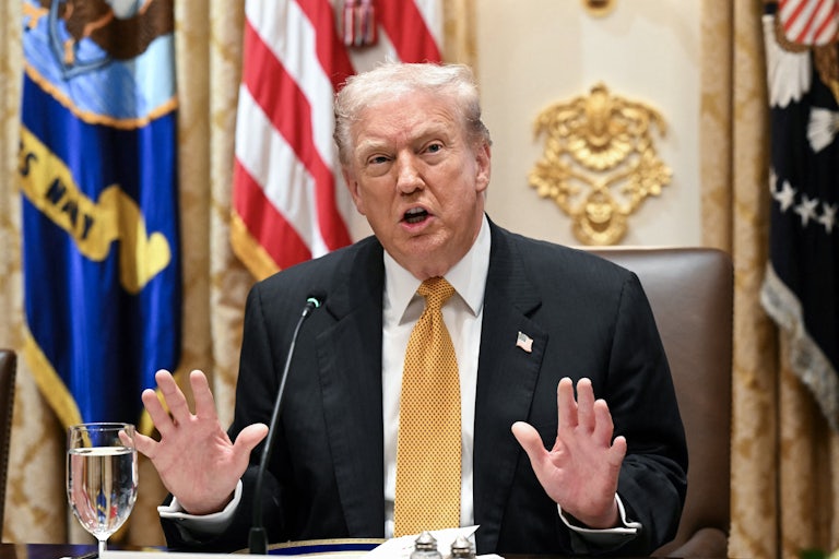 Donald Trump puts both hands up defensively as he speaks in the White House.