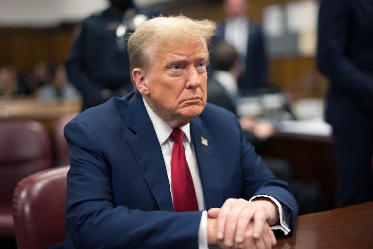 Donald Trump sits with his hands folded