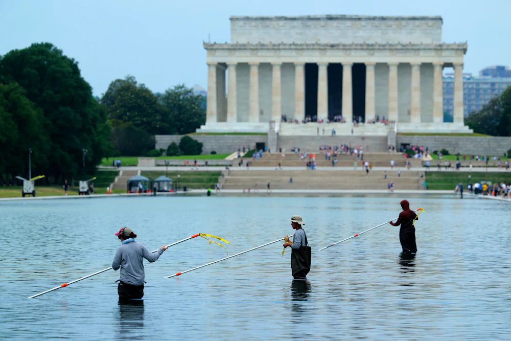 National Park Service employees and contractors use vacuums to remove green algae from the bottom of the Lincoln Memorial Reflecting Pool. The NPS is working to control and remove the algae bloom that has turned the pool green following the Trump Administration’s recent $14 million repair, resealing and painting project.